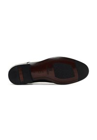Suela de zapato de cuero negro con secciones de goma texturizada, acento de madera y logotipo de marca en relieve. Costuras detalladas a lo largo de los bordes.