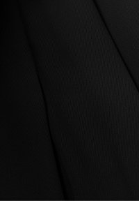 Černá tkanina s texturovaným povrchem, s diagonálním žebrováním. Materiál vypadá hladce a je lehký, s hlubokou barevnou sytostí.