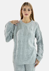 Jasnoszary sweter dzianinowy z teksturowanym wzorem w warkocze, szerokim okrągłym dekoltem i ściągaczami, prezentujący luźny, casualowy fason.