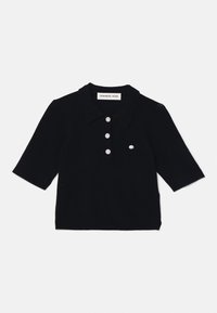 Czarna koszulka polo z krótkim rękawem, wykonana z materiału dzianinowego, z kołnierzykiem w kształcie spiczastym, trzema guzikami oraz małą kieszonką na piersi.