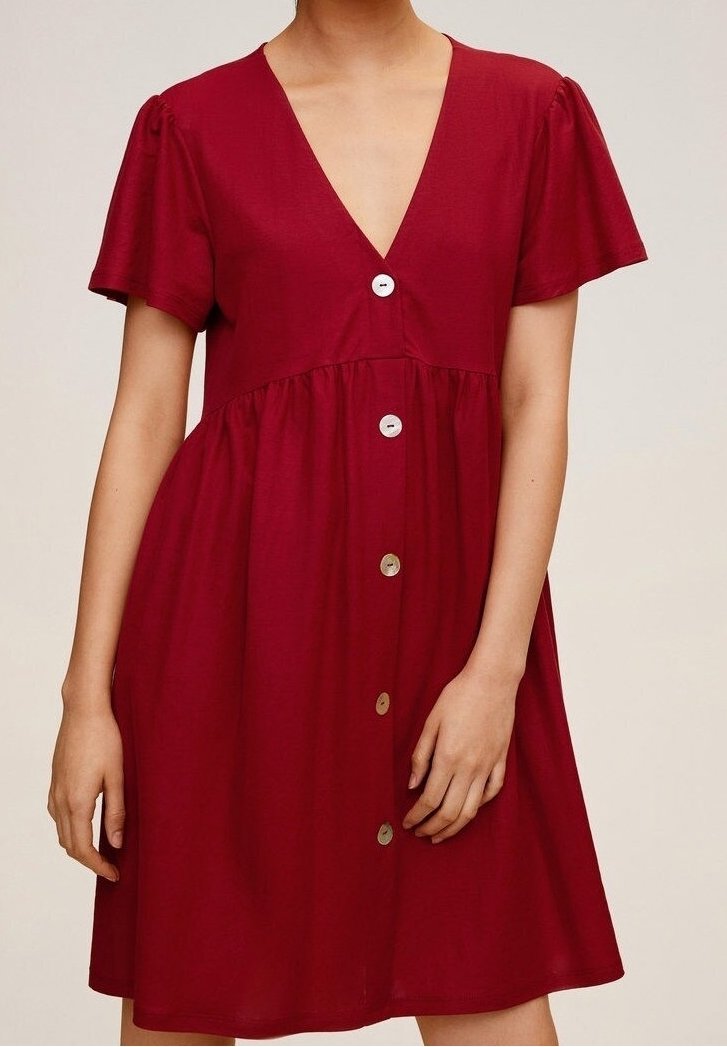Abito rosso a maniche corte con scollo a V, chiusura frontale con bottoni, vita arricciata e tessuto morbido. Presenta bottoni argentati e una silhouette fluida.