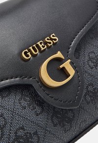 Pochette in finta pelle nera con texture, logo "GUESS" dorato e accentuazione "G", dotata di chiusura a pattina e motivo goffrato sottile.