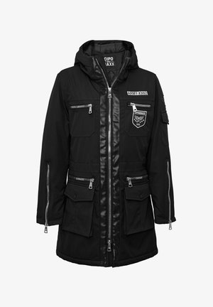 Parka noire à capuche avec plusieurs poches zippées, écussons avant portant les inscriptions « ARMY-XX62 » et « CIPO&BAXX 666 », et garniture en cuir le long de la fermeture éclair.