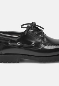 Schwarze Lederschuhe im Boots-Stil mit glatter Oberfläche, runder Zehenform, Schnürdesign mit silbernen Ösen und einer strukturierten Gummisohle.