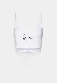 Biały crop top z cienkimi ramiączkami, wiązaniem w talii oraz czarnym haftowanym podpisem "Kanye" z przodu. Miękki, elastyczny materiał.
