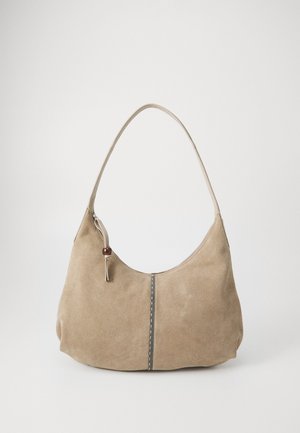 Borsa a spalla in suede beige con manico curvo, chiusura a zip e decorazione in perline marroni. Presenta una cucitura verticale centrale e una texture morbida.