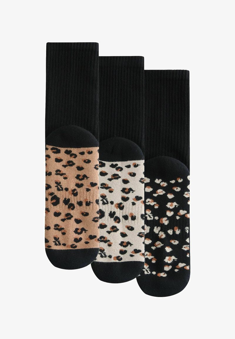 Trois paires de chaussettes alliant noir, beige et crème avec des motifs léopard et des bords unis noirs.
