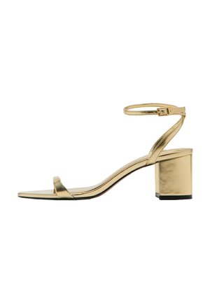 Złoty metaliczny sandał na obcasie typu blok z odkrytymi palcami i cienkim paskiem wokół kostki z małą klamrą.