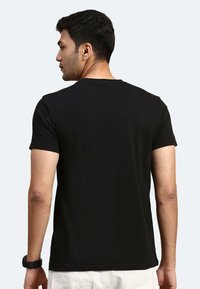 T-shirt nera in cotone con collo rotondo, maniche corte e vestibilità rilassata, caratterizzata da una texture liscia e un design minimalista.