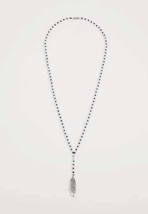 Nauha koru, jossa on vuorottelevia mustia ja valkoisia helmiä, ja keskellä roikkuu hopeinen höyheniriipus.