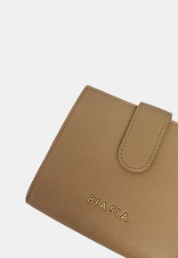 Braunes Lederportemonnee mit glatter Oberfläche, ausgestattet mit einem Klappenverschluss und dem eingeprägten "BIASIA"-Logo in Gold. Die genähten Kanten sind sichtbar.