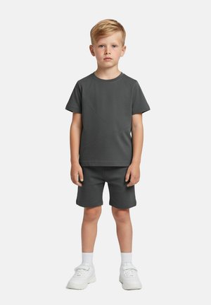 Szary bawełniany t-shirt z krótkim rękawem i szorty z ukośnymi przeszyciami. W zestawie białe trampki i prosty design.