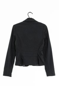 Svart figursydd jacka med en strukturerad krage, långa ärmar och sidfickor. Har synlig sömnad och textil med struktur.