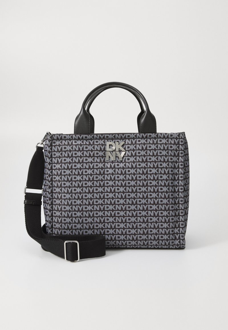 Saco DKNY com um tecido preto texturizado com padrão de logótipos repetidos, alças em couro preto e uma alça ajustável preta. Acessório em metal prateado.