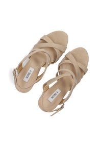 Beige suède sandalen met kruisbanden, open teenontwerp en enkelgesp. Voorzien van een platte zool en merklabel aan de binnenkant.