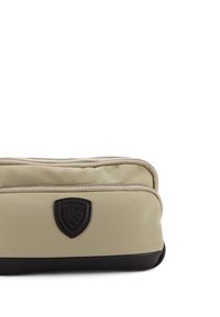 Pochette con cerniera in tessuto beige con fondo nero, dotata di un'emblema scuro e di un design a doppia cerniera per un facile accesso.