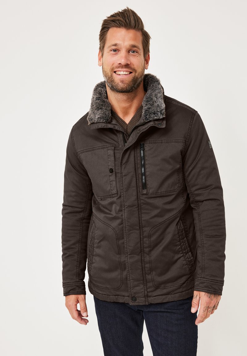 Dunkelbraune Jacke mit einem grauen Kunstfellkragen, ausgestattet mit frontalen Taschen und einer Reißverschlusstasche, aus strukturiertem Stoff mit sichtbaren Nähten.