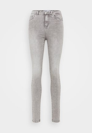 Hallide sinised teksad, millel on tuhm pesu, kõrge vöökoht, viie tasku disain ja vööloopide koht. Valmistatud denimkangast, millel on kerge venivus.