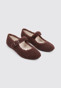 Brown fluffy Mary Jane shoes with a soft texture, round toe, and a single adjustable strap across the instep. Lightweight design.