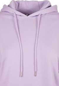 Hanorac lila dintr-un material moale, cu glugă ajustabilă cu șnururi metalice și un finisaj texturat. Design simplu și lejer.