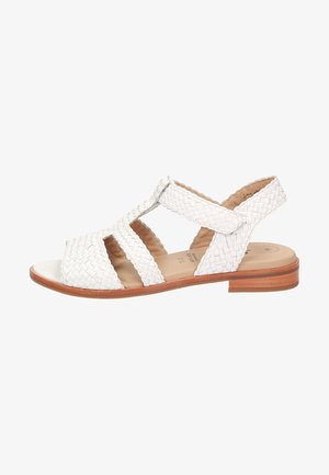 White woven leather sandal with open cutouts, flat wooden heel, and adjustable strap for secure fit. Smooth interior sole, casual design.