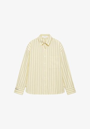 Világos sárga gombos ing vékony függőleges barna csíkokkal, hosszú ujjakkal, gallérral, mellzsebbel és apró felirattal a bal mandzsettán.