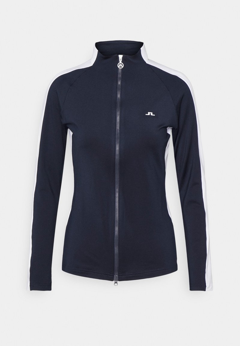 Námořnicky modrý sportovní kabát z elastické látky s vysokým límcem, celým zipem a bílými bočními pruhy. Na hrudi má malé logo.