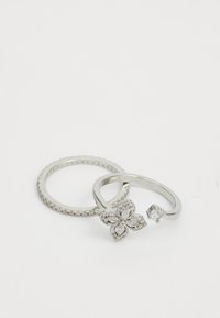 Zwei Ringe sind ausgestellt. Der eine Silberring hat kleine runde Steine, und der zweite zeigt ein Blumendesign mit marquise-förmigen Steinen und einem einzelnen Steinakzent.