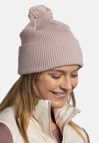 Light pink knit beanie with a ribbed texture and a pom-pom on top. Features a snug fit and soft material for warmth.