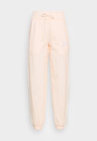 Jogger kalhoty v světle broskvové barvě s elastickým pasem, šňůrkou v pase, bočními kapsami a elastickými manžetami. Obsahují malé bílé logo.