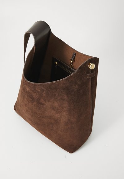 Sac à épaule en daim marron avec une forme incurvée, une poignée en cuir et un bouton d'accent doré. L'intérieur dispose d'une poche zippée et d'un revêtement beige.