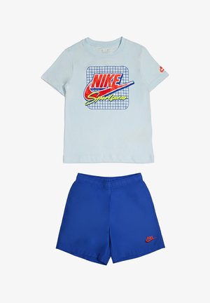 Camiseta Nike azul claro con logo rojo y amarillo encima de pantalones cortos deportivos azules con pequeño logo rojo de Nike en la pierna izquierda.