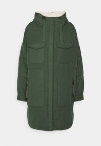 Grön vadderad kappa med huva, som har två bröstfickor, sidofickor med dragkedja och en mjuk foder. Designad med rak skärning och justerbara snoddar.