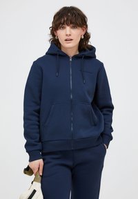 Felpa aperta blu navy in misto cotone, con tasche frontali, cappuccio regolabile con cordino e polsini e orlo a coste.