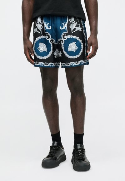 Pantaloncini neri e blu con un dettagliato motivo ornato bianco e argento, con motivi di leone e volute. Realizzati in tessuto leggero.