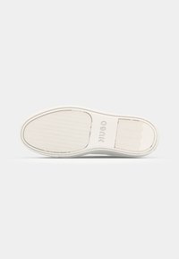 White rubber shoe sole with textured grip pattern, featuring "HUGO" branding, smooth edges, and a curved toe design.