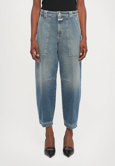 Lyseblå denimjeans med løs pasform, der har skrå forlommer, høj talje og subtilt slid på benene.