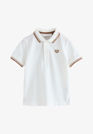 Polo bianca a maniche corte con collo e polsini a righe marroni, due bottoni e un piccolo ricamo di orsacchiotto sul petto.