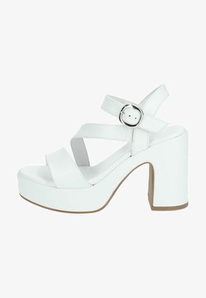 Le sandali platform bianchi presentano un tacco grosso, cinturini incrociati e una punta tonda. Realizzati in materiale sintetico con una texture liscia e fibbia in metallo.