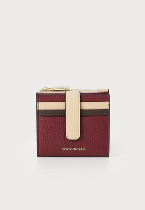 Small textured leather wallet in burgundy, beige, and brown with a front snap strap and gold zipper on top.