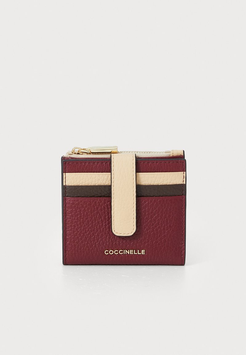 Small textured leather wallet in burgundy, beige, and brown with a front snap strap and gold zipper on top.