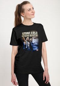 Černé bavlněné tričko s grafickým potiskem zápasníka a výrazným nápisem "STONE COLD STEVE AUSTIN" a logem WWE v rohu.