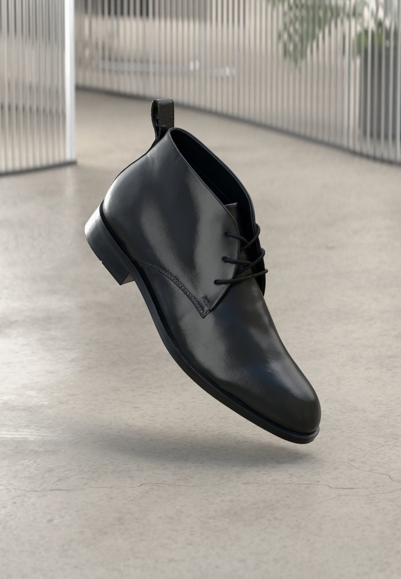 Črne usnjene gležnjarje z gladko površino, okroglo konico in vezanjem spredaj. Imajo majhen peti in zadnji nastavitev za enostavno obuvanje.