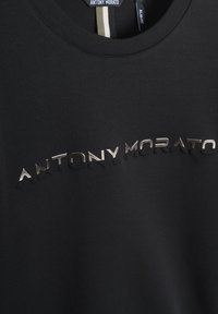 T-shirt nera in cotone con scollatura rotonda, caratterizzata da scritte metalliche in rilievo "ANTONY MORATO" sulla parte anteriore. Design slim-fit.