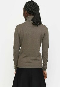 Rjava turtleneck pulover iz pletenega blaga, z dolgimi rokavi, rebrastimi manšetami in oprijetim krojem.