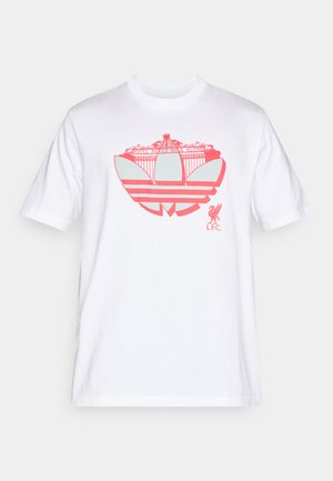 Vit bomullst-shirt med en stor rosa Adidas-logotyp med texten Liverpool och grafiska designelement. Kortärmad med rundhalsringning.