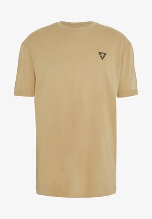 Camiseta beige de manga corta con cuello redondo y pequeño logo negro geométrico en forma de triángulo en el pecho izquierdo.