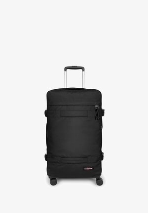 Maleta negra con ruedas, fabricada con tela resistente, que cuenta con un asa telescópica, ruedas suaves y un compartimento con cremallera y hebillas.