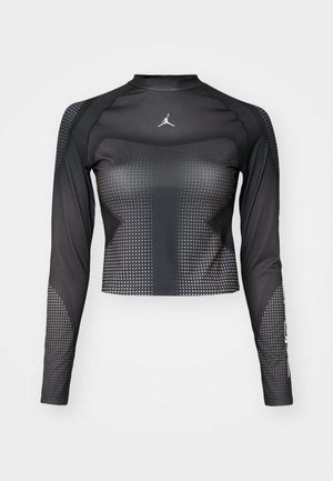Long-sleeve black sports top with a fitted design, featuring dot patterns and a small logo on the chest. Made of sleek, stretchy fabric.