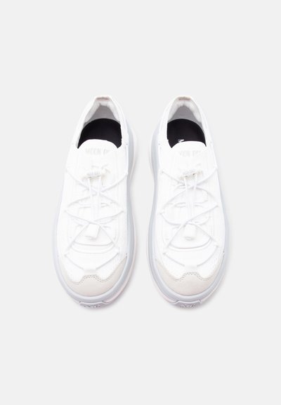 Ζευγάρι λευκά αθλητικά παπούτσια με κορδόνια και παχιά σόλα, ορατά από πάνω σε απλό ανοιχτό φόντο.